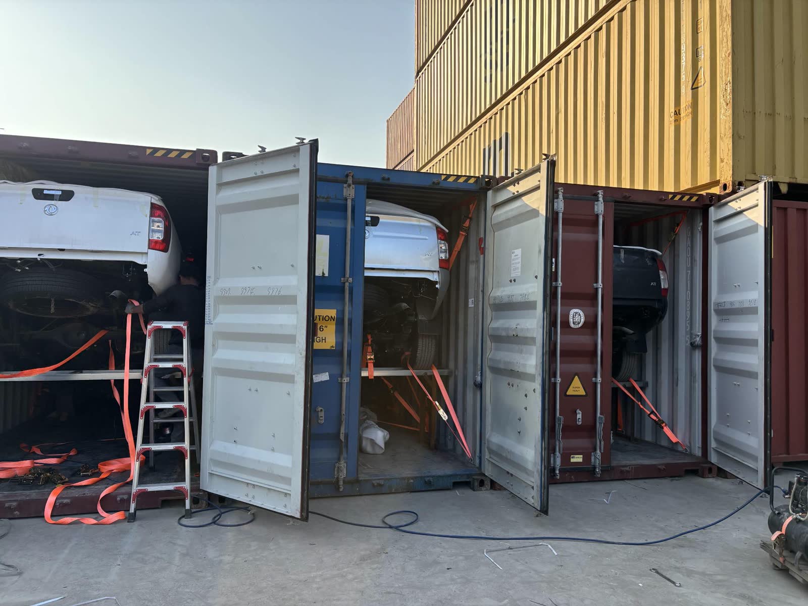 Pickup trucks racked inside 40ft containers before the doors are closed