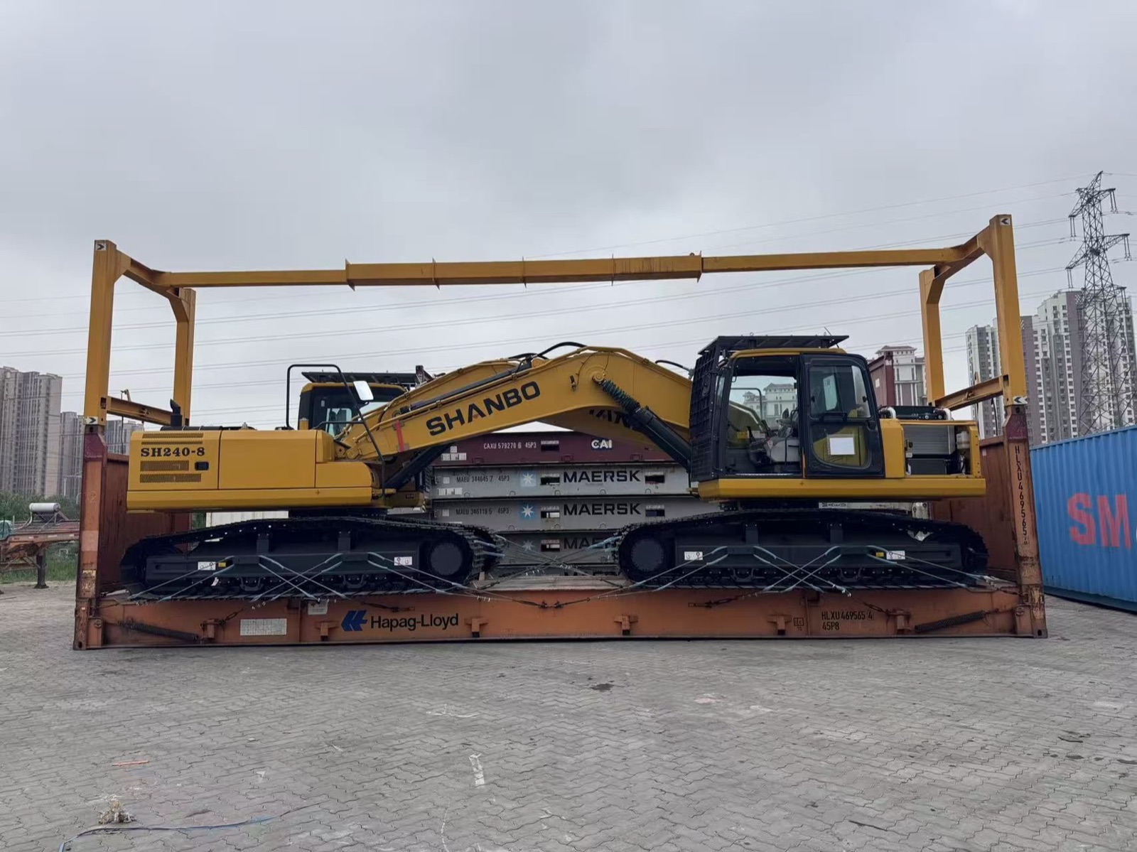 Tracked excavator loaded and lashed on a flat rack platform, front view