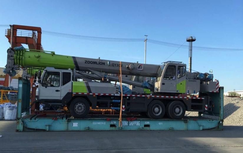 Truck crane loaded whole on a flat rack, side view