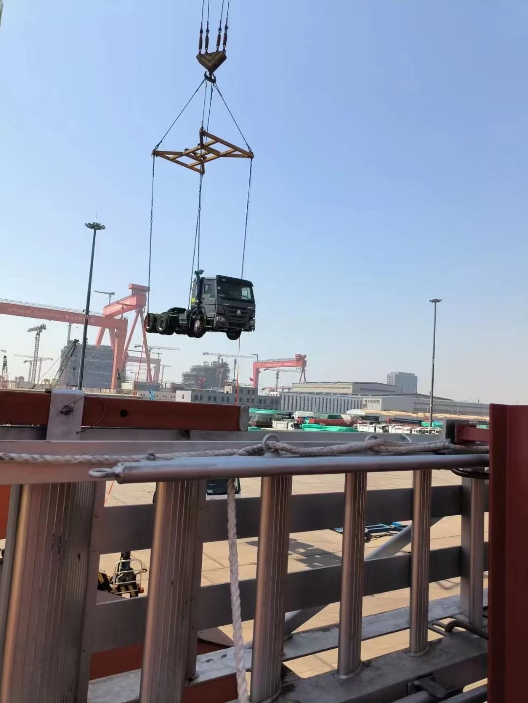A truck tractor head lowered to the vessel deck by crane